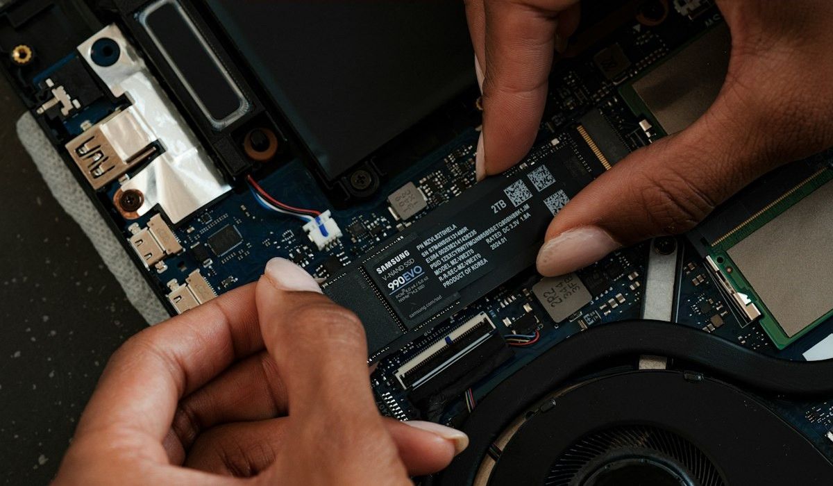 Hands replacing a laptop component